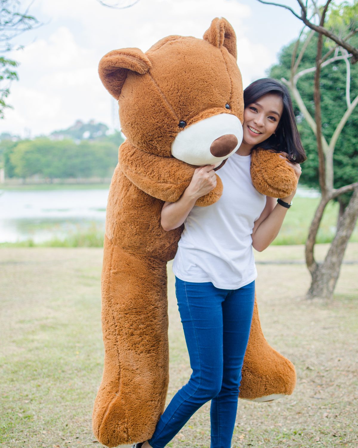 Woman hugging a giant brown teddy bear from Oppa Bear